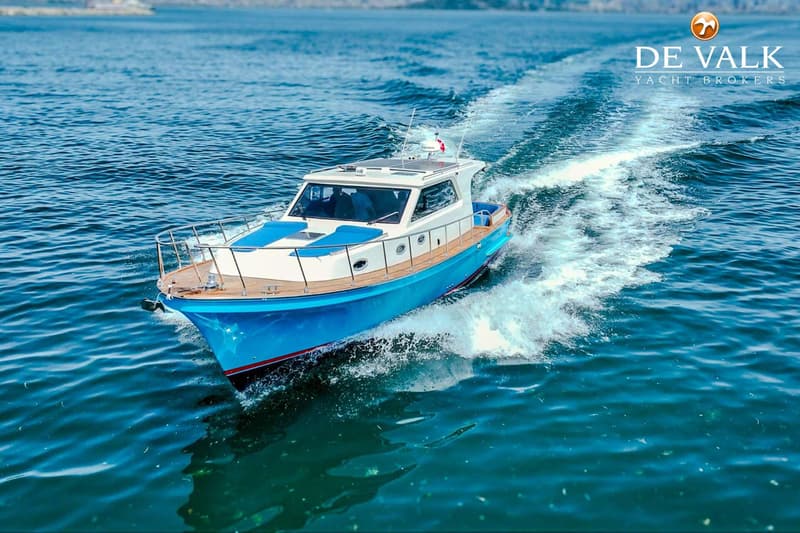 Een blauw-witte motorboot vaart over het water en creëert een kielzog achter zich. — Lobster 42 OC