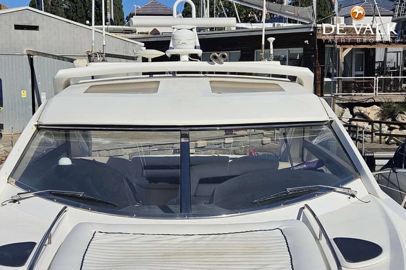 Een witte boot met een grote voorruit en twee ruitenwissers, liggend in een haven. — Sunseeker Portofino 53