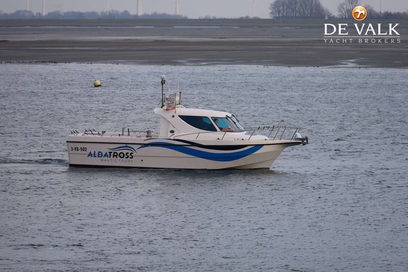 Een witte boot met blauwe strepen en de tekst "ALBATROSS NAUTIC TOURS" vaart op het water. — Waypoint 34
