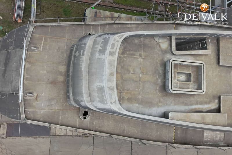 Een bovenaanzicht van een onafgewerkte boot met een rechthoekige opening en een vierkant luik.