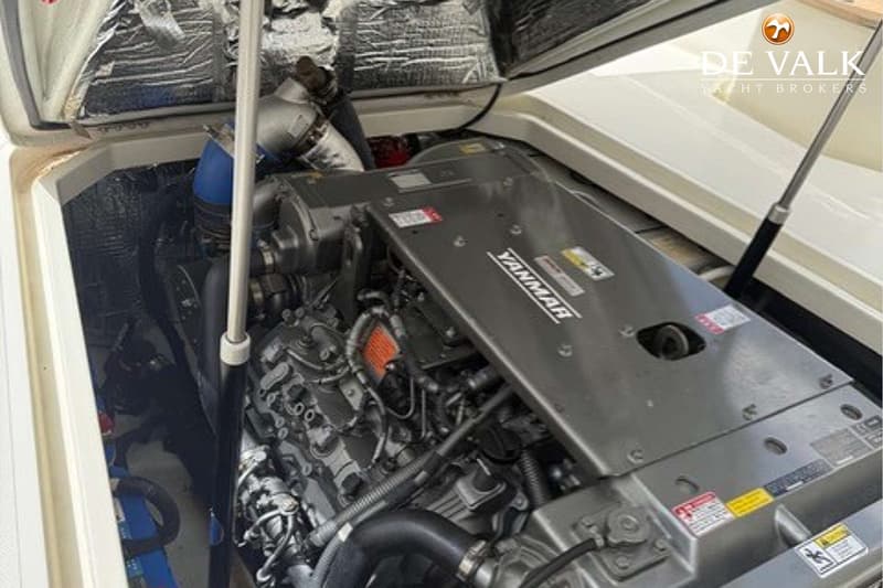 De foto toont een Yanmar scheepsmotor in een motorruimte met isolatiemateriaal en een gasveer.
