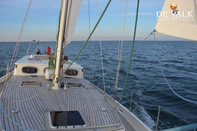 Een zeilboot met een houten dek vaart op open water, met een deel van het zeil en de mast zichtbaar. — Puffin 42