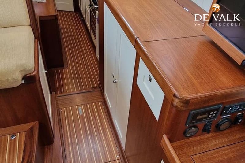 De foto toont een interieur van een boot met een houten vloer, houten meubels en witte kasten. — Puffin 42