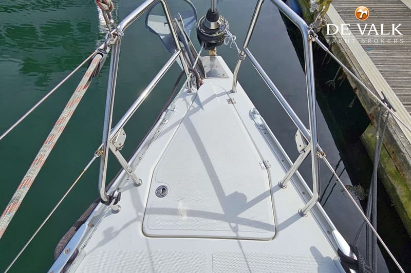 De foto toont de boeg van een witte boot met een roestvrijstalen reling, liggend aan een houten steiger. — Hanse 375