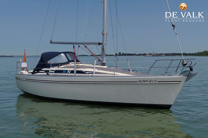 Een witte zeilboot met de naam "MORPHEUS" ligt in het water onder een heldere blauwe lucht. — Moody 336