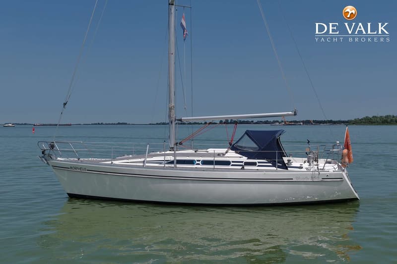 Een witte zeilboot met de naam "MORPHEUS" en "Moody 336" ligt in het water onder een helderblauwe lucht. — Moody 336