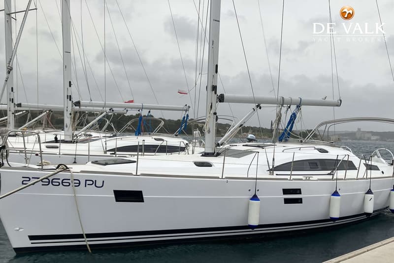 Een witte zeilboot met blauwe en zwarte strepen op de romp ligt aangemeerd, met een registratienummer 279669 PU.