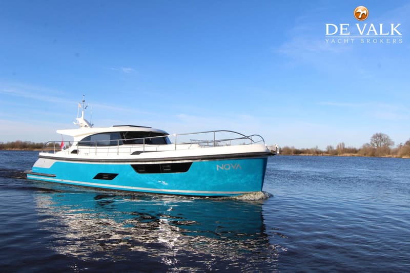 Een blauw-witte motorboot met de naam "NOVA" vaart op een waterweg onder een helderblauwe lucht. — Vripack 45 OK