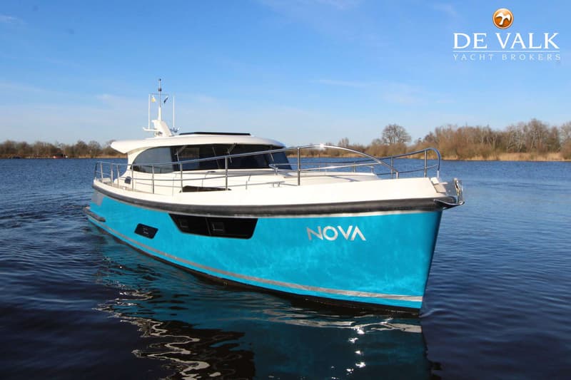 Een blauw-witte motorboot met de naam "NOVA" op de boeg, drijvend op water onder een heldere blauwe lucht. — Vripack 45 OK