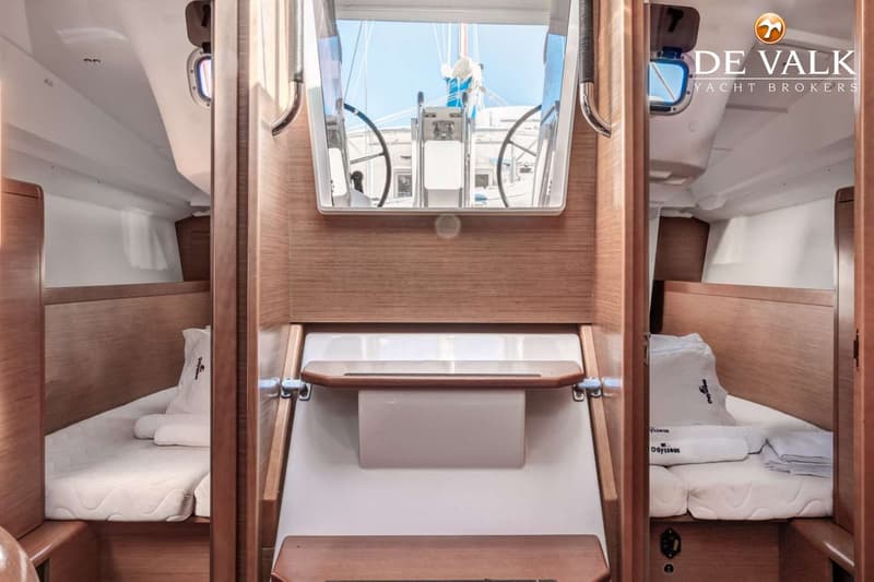 De foto toont het interieur van een boot met twee bedden aan weerszijden en een trap naar de kuip. — Jeanneau Sun Odyssey 349