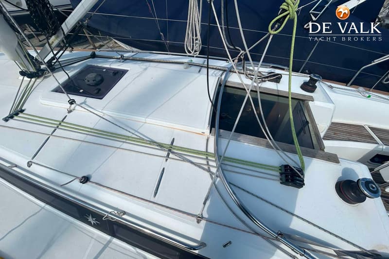 De foto toont een bovenaanzicht van het dek van een zeilboot met touwen, luiken en een lier. — Jeanneau Sun Odyssey 349