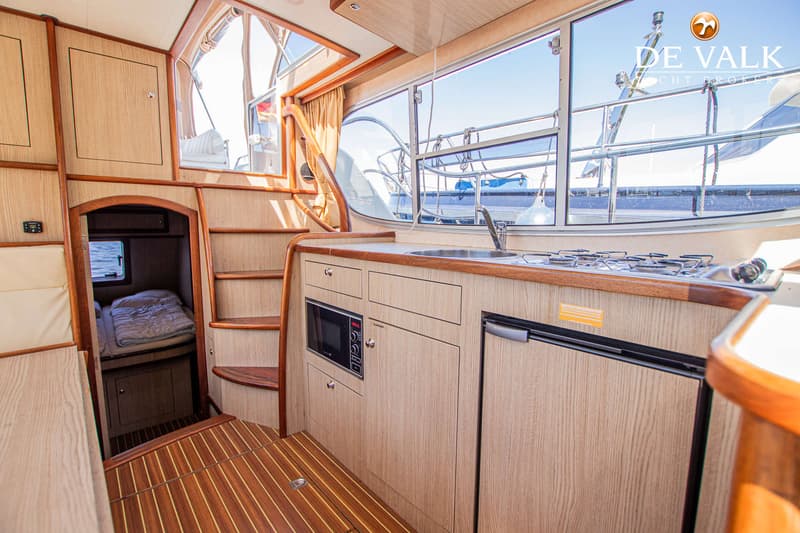 Een interieur van een boot met een keukenblok, een slaapcabine en een trap naar een hoger dek. — Gruno 37 Classic