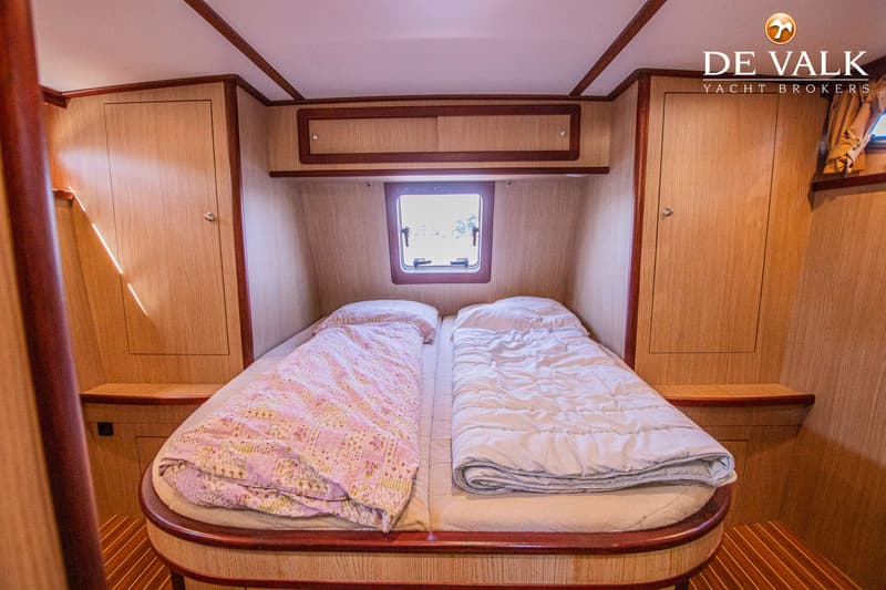 Een kajuit met twee eenpersoonsbedden, een raam, en houten kasten en panelen. — Gruno 37 Classic