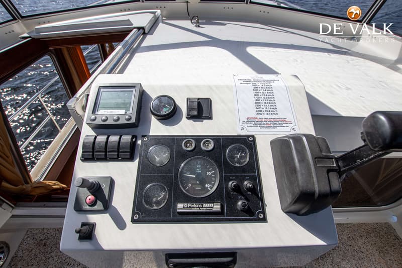 Een detailfoto van het dashboard van een boot met diverse meters, schakelaars en een bedieningshendel. — Pedro Marin 30