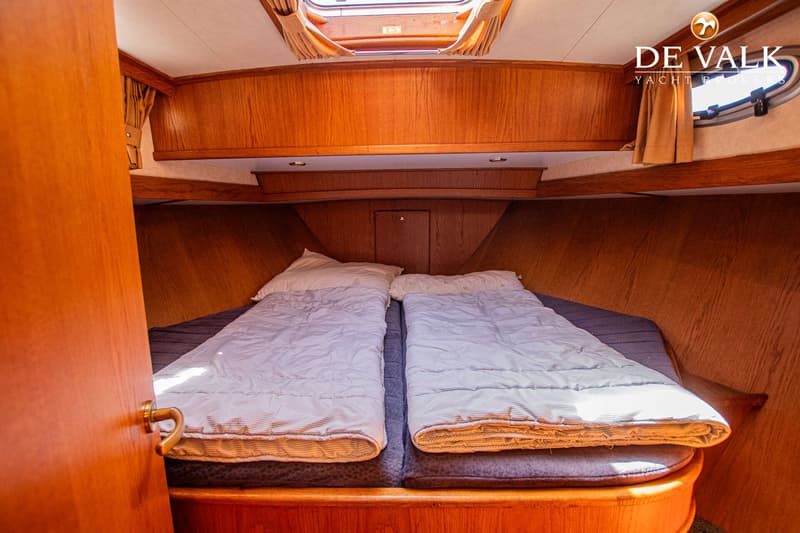 De foto toont een kajuit met twee bedden, houten wanden en een luik in het plafond. — Gruno 36 Classic