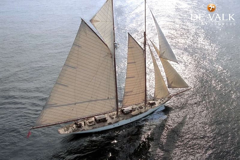 Een zeilboot met meerdere masten en zeilen vaart over glinsterend water, gezien vanuit de lucht. — Schooner Classic gaff