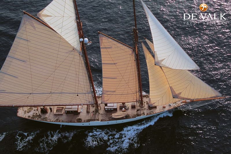 Een zeilboot met meerdere masten en zeilen vaart over donker water, gezien van bovenaf. — Schooner Classic gaff