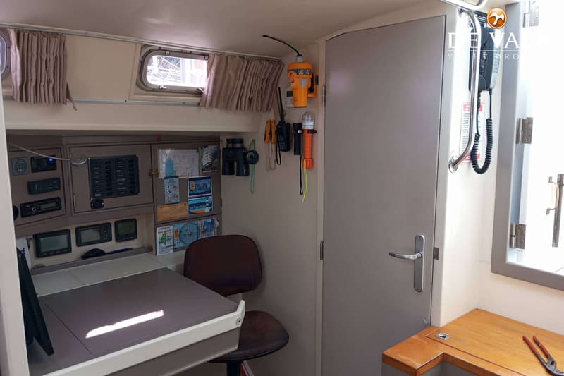Een interieur van een boot met een navigatietafel, instrumentenpanelen, een stoel, en een deur. — Van de Stadt 48