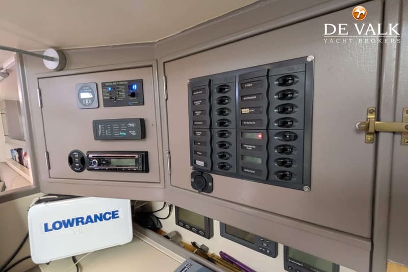 Een close-up van een bootinterieur met een Lowrance HDS-apparaat en een bedieningspaneel met schakelaars.