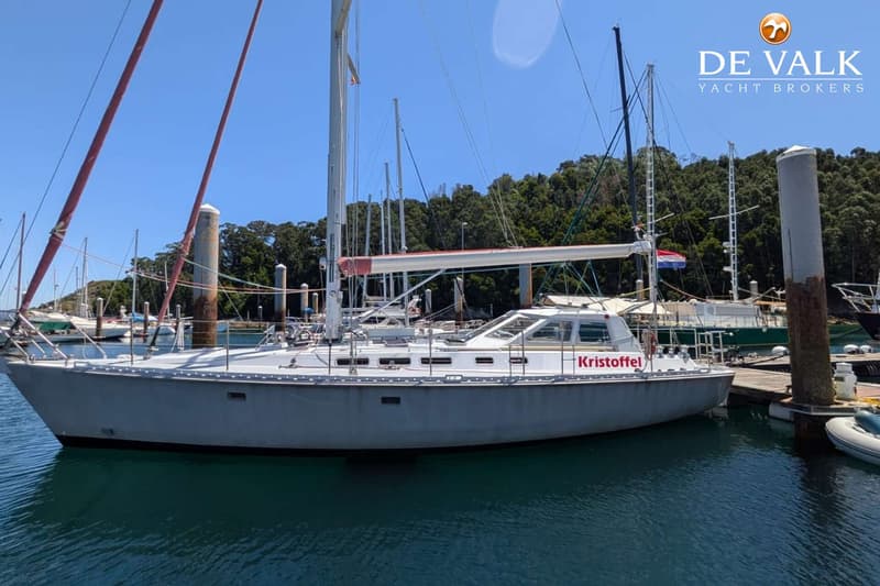 Een grijze zeilboot met de naam "Kristoffel" in rode letters ligt aangemeerd in een haven. — Van de Stadt 48