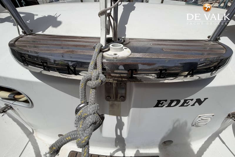 De foto toont het achtersteven van een witte boot met een houten en chromen zwemplateau, en de naam "EDEN" in zwarte letters.