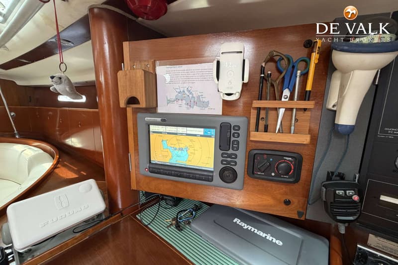Een Raymarine kaartplotter toont een kaart van een watergebied, omringd door diverse navigatie- en communicatieapparatuur.