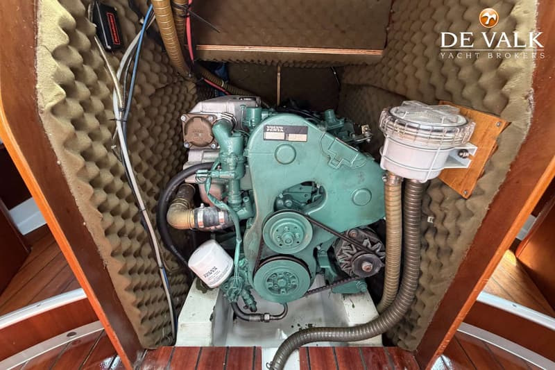 Een Volvo Penta motor is zichtbaar in een motorruimte met geluidsisolatie en houten afwerking.