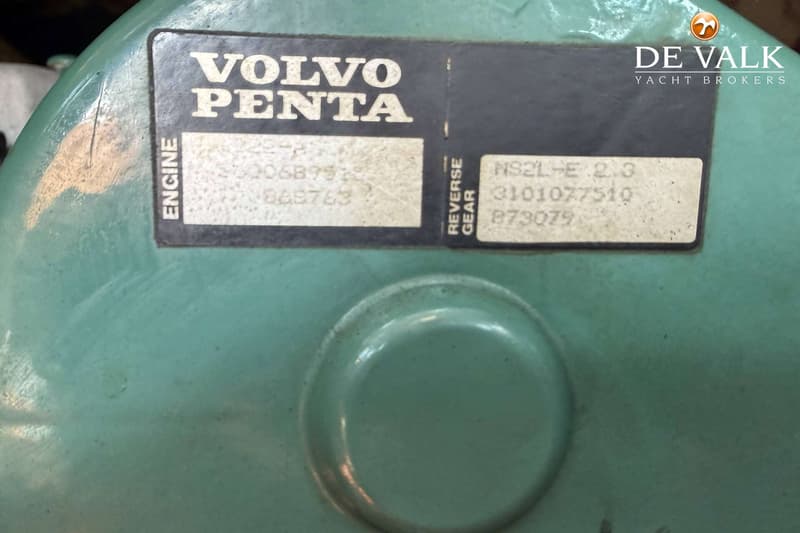 Een close-up van een groen motoronderdeel met een zwart-wit label van "VOLVO PENTA" en serienummers.