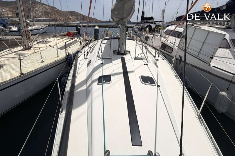 Een bovenaanzicht van het dek van een witte zeilboot met twee luiken en een zwarte strook in het midden.