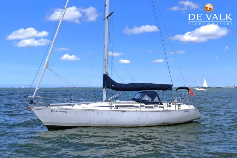 Een witte zeilboot met de naam "The Other Side" en "First 405" ligt op het water onder een blauwe lucht. — Beneteau First 405