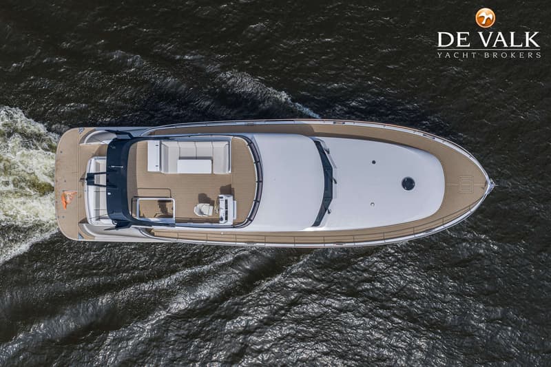 Een bovenaanzicht van een witte motorboot met een houten dek, varend op donker water. — Van der Heijden Exclusive Deluxe 2000