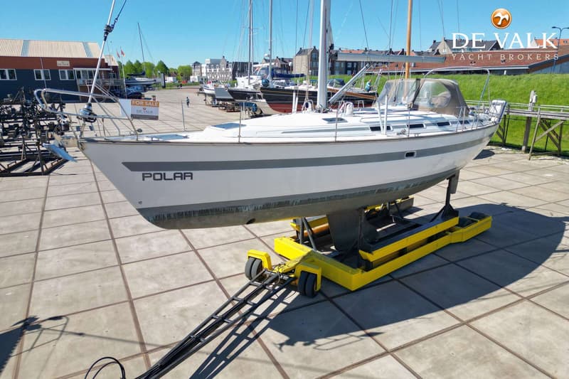 Een witte zeilboot met de naam "POLAR" staat op een gele trailer op een betonnen terrein. — Bavaria 42 Exclusive