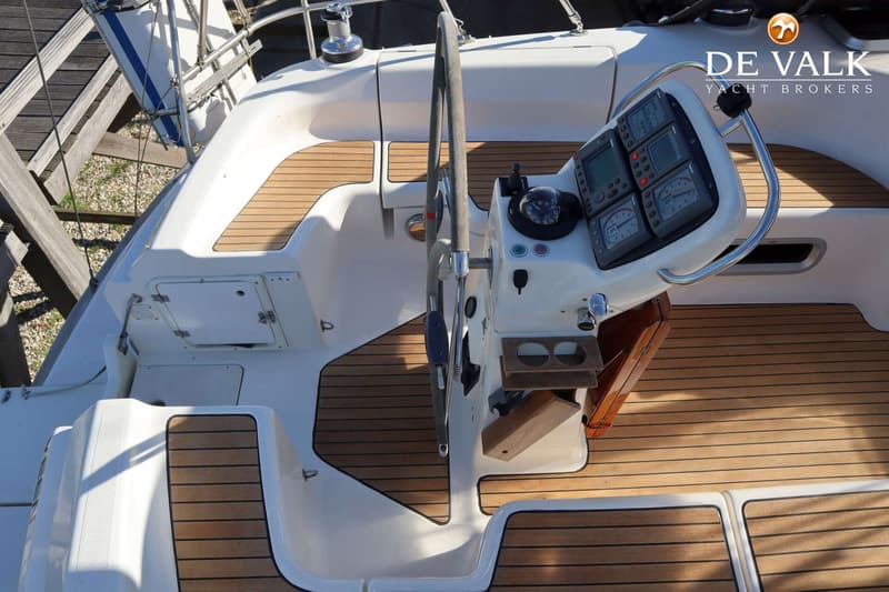 Een stuurstand met een stuurwiel, navigatie-instrumenten, een kompas en een houten vloer.