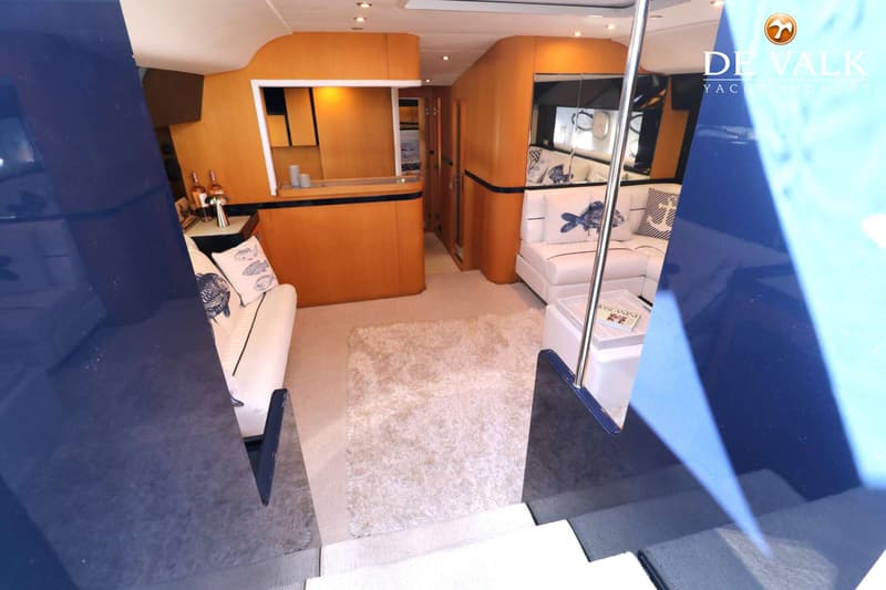 Een interieur van een boot met twee witte banken, een houten bar en een tapijt op de vloer. — Riva 60 Bahamas