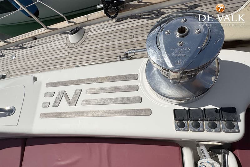 Een detailfoto van een Andersen 28ST Two Speed lier, vier zwarte knoppen en een houten dek.