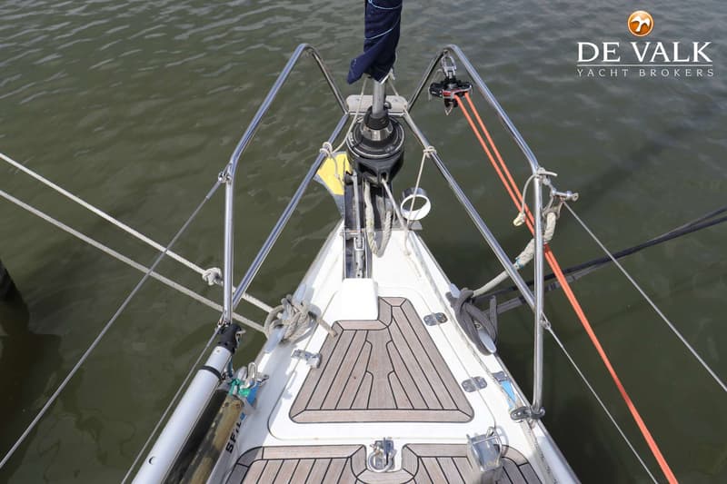 De foto toont de boeg van een zeilboot met een teakdek, reling, een opgerold zeil en diverse lijnen. — Dehler 39 SQ