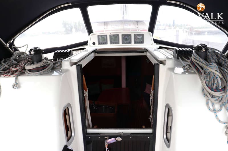 Een bovenaanzicht van de kuip van een zeilboot met een open kajuitingang, lieren en instrumenten. — Dehler 39 SQ
