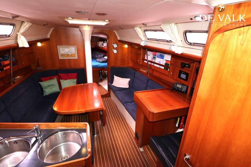 De foto toont het interieur van een boot met een kombuis, salon en een doorgang naar een slaapcabine. — Dehler 39 SQ