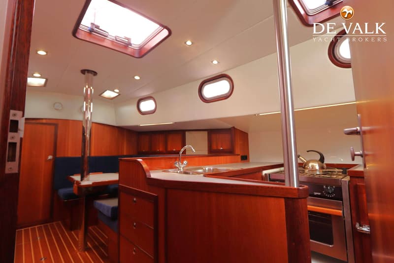 Een interieur van een boot met een kombuis, zithoek en houten afwerking. — Bornrif 33
