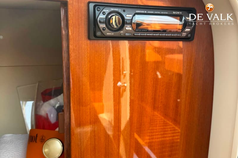 Een Sony autoradio is ingebouwd in een glanzend houten paneel, met een open kastje ernaast.