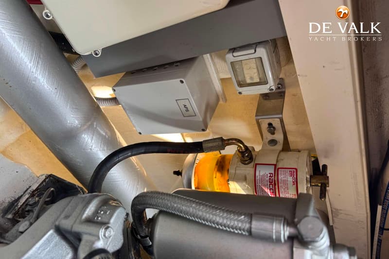 Een detailfoto van een Racor brandstoffilter met een doorzichtige kom, diverse slangen en bedrading in een motorruimte.