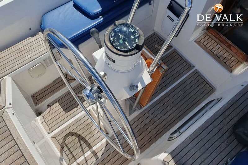 Een stuurwiel met kompas en een teakdek zijn zichtbaar in de kuip van een boot. — Nauticat 32