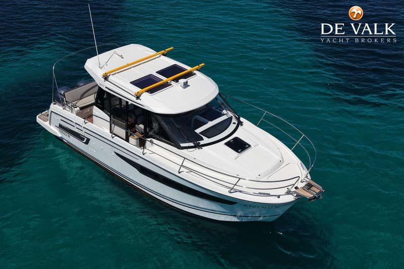 Een witte motorboot met de naam "Eternity" ligt in helder, turquoise water. — Jeanneau Merry Fisher 895 offshore