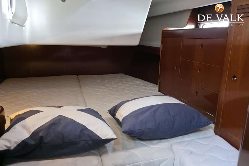 Een kajuit met een tweepersoonsbed, twee kussens, en houten kasten. — Beneteau First 47.7
