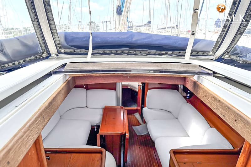 Een interieur van een boot met houten vloer en witte banken, gezien vanuit de kuip naar de kajuit. — Grand Soleil 38