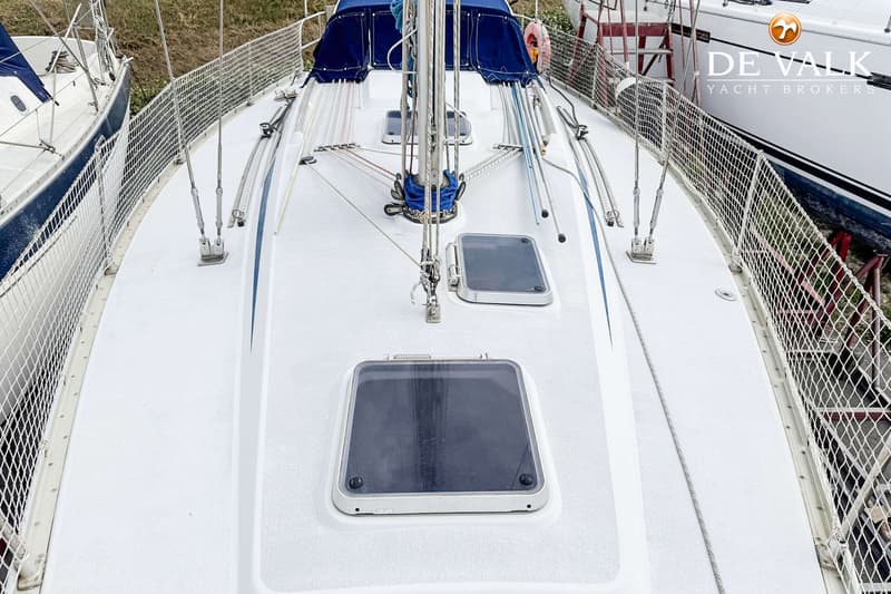 Een bovenaanzicht van het witte dek van een zeilboot met twee luiken, een mast en diverse lijnen. — Grand Soleil 38