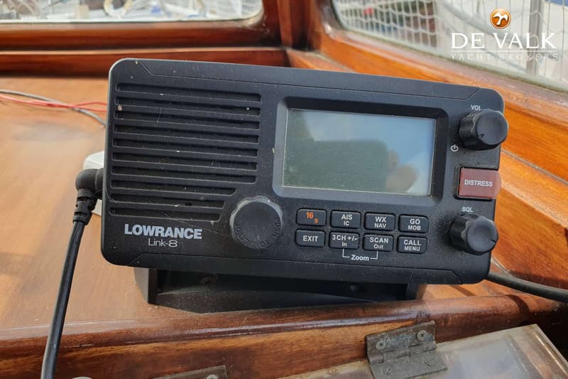 Een Lowrance Link-8 marifoon met een scherm en diverse knoppen is gemonteerd op een houten oppervlak.