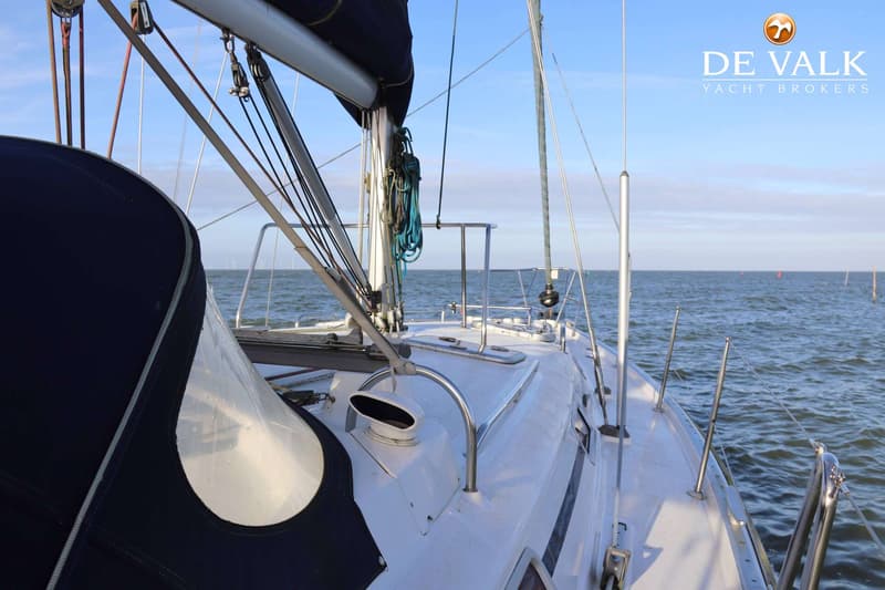 Een zeilboot op het water met een blauwe buiskap en een mast met touwen, onder een blauwe lucht. — Beneteau Oceanis 411