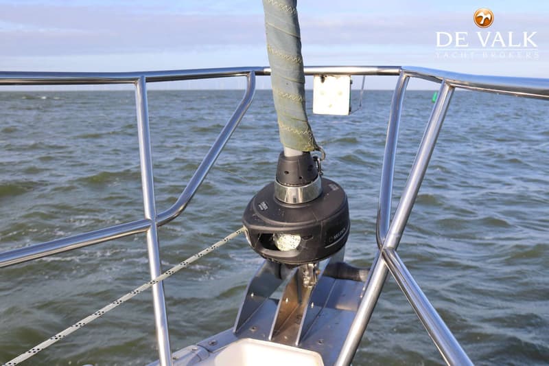 De foto toont de boeg van een boot met een rolfoksysteem, ankerrol en reling, met water en de horizon op de achtergrond.