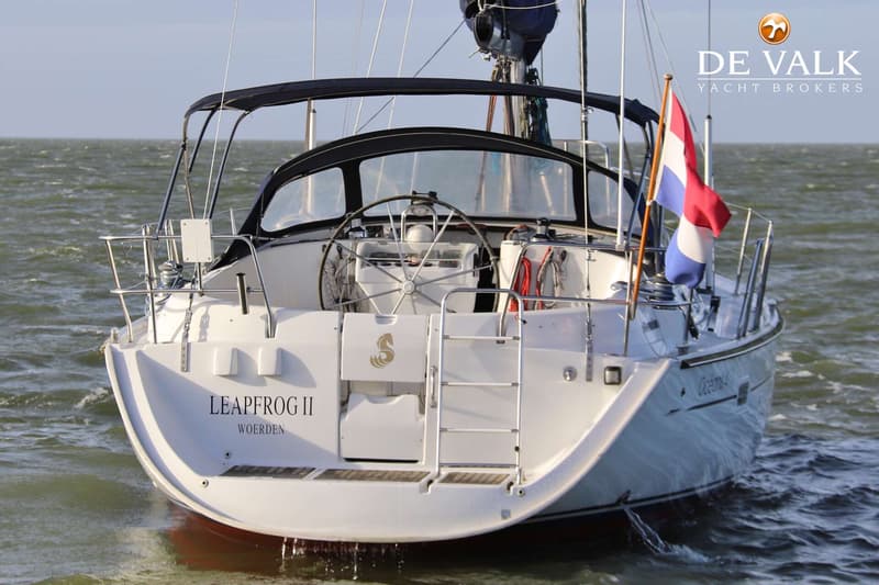 Een witte zeilboot met de naam "LEAPFROG II WOERDEN" op de spiegel, een Nederlands vlaggetje en een stuurwiel.
